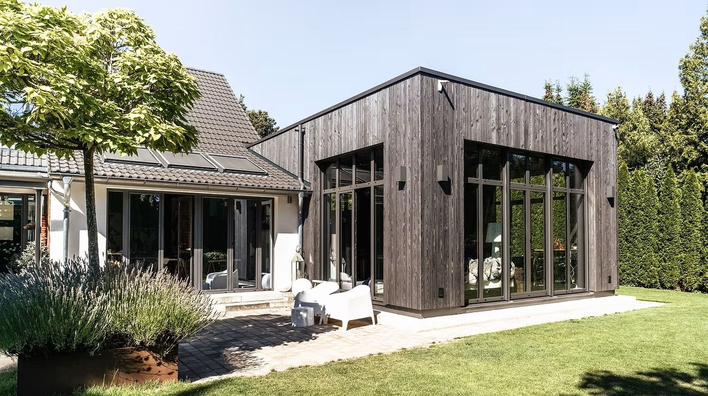 Außenansicht eines modernen Hauses mit Holzverkleidung und großen Fenstern