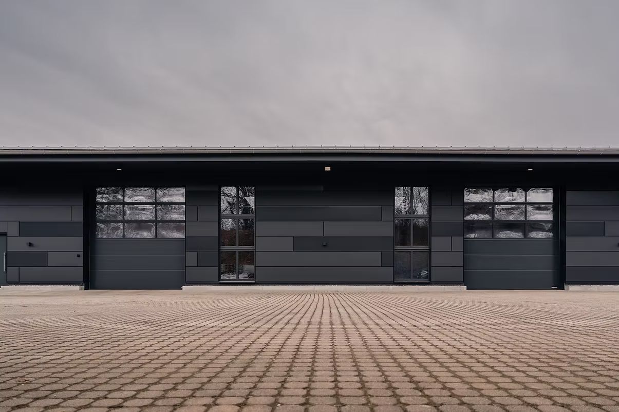 Ansicht einer modernen Gebäude-Fassade mit großen Fenstern und einem minimalistischen Design.