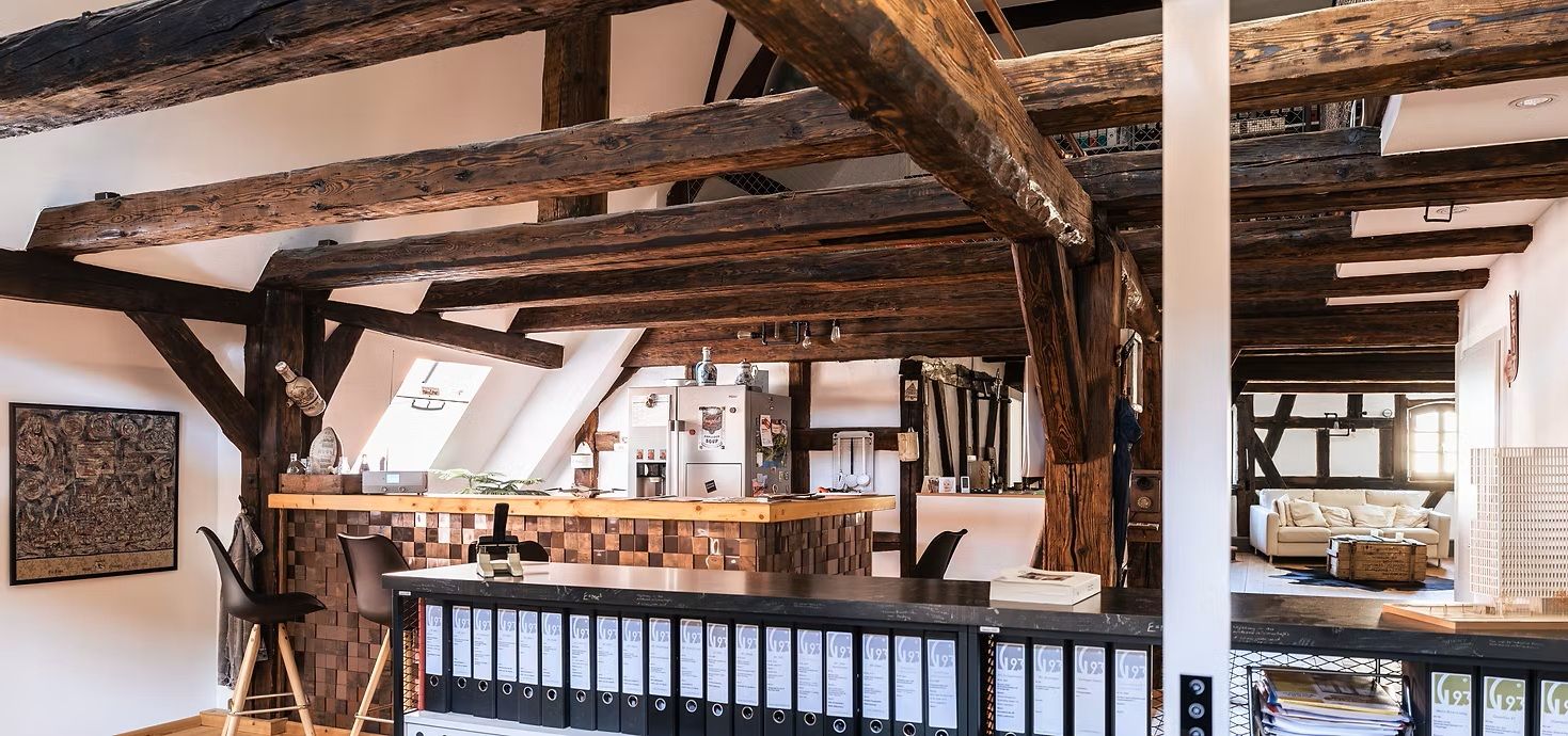 Rustikaler Innenraum mit sichtbaren Holzbalken und moderner Einrichtung